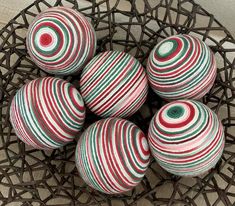 six striped balls sitting on top of a wire basket