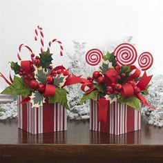 two red and white striped boxes with candy canes in them sitting on a table