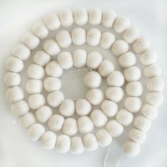 a string of white beads on a white surface