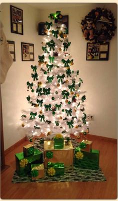 a white christmas tree with presents under it