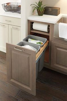 an open cabinet in the middle of a kitchen with towels and other items inside it