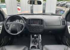 the interior of a car with black leather seats and dash board, steering wheel and dashboard