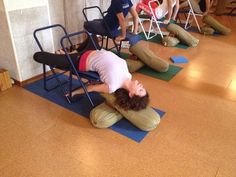 a person laying on the ground in front of some chairs and people sitting around them