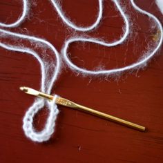 a pair of scissors sitting on top of a table next to some white yarn and thread