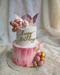 a three tiered cake with pink and gold decorations