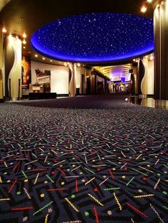 the inside of a building with carpeted floors and blue sky above it at night