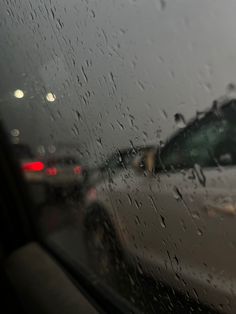 rain is falling on the windshield of a car