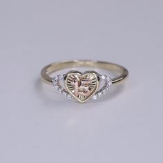 a heart shaped diamond ring with a tree in the middle and two diamonds on each side