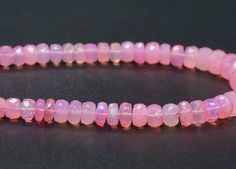 a pink beaded bracelet on a black surface