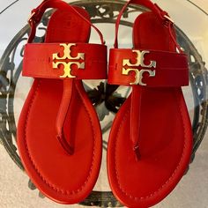 New! Never Worn!! A Classy And Comfortable Style, These Red Leather Bryce Flat Sandals From Tory Burch Go With Any Outfit. A Gleaming Gold Hardware Tory Burch T Logo Medallion Takes Center Stage On A Beautifully Smooth Thong Sandal Fitted With An Adjustable Buckle Slim Slingback Strap, A Padded Footbed, A Leather Outsole And A Stacked Low Heel. Color: Red With Gold Hardware Material: Leather Upper; Rubber Sole Size: 7m Red T-strap Sandals With Ankle Strap, Red Ankle Strap T-strap Sandals, Red Open Toe T-strap Sandals, Red Leather T-strap Sandals, Red T-strap Sandals For Beach, Red Sandals With Branded Insole And Single Toe Strap, Red Sandals With Single Toe Strap, Red T-strap Sandals For Spring, T Logo