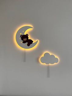 the teddy bear is sitting on the crescent moon and cloud wall decals are lit up