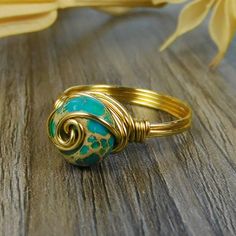 "Blue Imperial Jasper Gemstone and Sterling Silver, Yellow or Rose Gold Filled Wire Wrapped Swirl Ring; Custom Made to Size ❀ This round turquoise imperial jasper gemstone bead and wire wrapped ring is handmade with an approximately 8mm by 5mm bead and your choice of wire for the band. ❀ This ring (as well as all the others in my shop) is custom made to any size from 4 to 14 including half and quarter sizes! ❀ This ring can be made in Sterling Silver Filled Wire, Argentium Sterling Silver wire ( Rings Made From Wire, Wired Rings, Diy Wire Jewelry Rings, Wire Jewelry Rings, Wrapped Rings, Diy Jewelry Display, Imperial Jasper, Wire Jewelry Designs, Swirl Ring