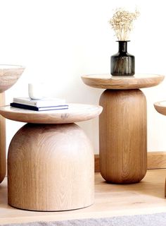 three wooden stools sitting next to each other on top of a carpeted floor