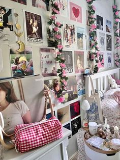 a bedroom with pink flowers on the wall and pictures all over the walls, along with stuffed animals