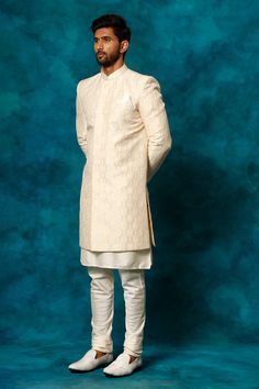 VASTRAMAY Men's Beige Imported Jacquard Indo With Kurta Pyjama Set Elevate your ethnic wear collection with this beige indo-western sherwani set. Crafted from a silk blend, this set features a jacquard patterned sherwani with a mandarin collar, button closure, and full sleeves. The kurta is a classic cream color with a mandarin collar, full sleeves, and pockets, and the set is completed with matching pyjamas. Dry clean only. Key Features Beige Indo-Western Sherwani Set Silk Blend Fabric Jacquard Festive Beige Kurta For Traditional Ceremonies, Traditional Beige Nehru Jacket For Transitional Season, Beige Traditional Wear For Eid Ceremonies, Beige Long Sleeve Traditional Wear For Diwali, Beige Long-sleeve Traditional Wear For Diwali, Traditional Beige Long Sleeve Sets, Ceremonial Beige Kurta For Eid, Beige Traditional Wear For Diwali Ceremonies, Beige Nehru Jacket With Zari Work