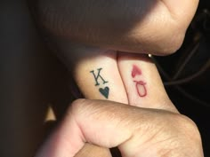 two people with matching tattoos holding each other's fingers and showing off their initials