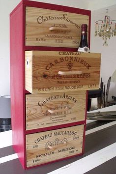 three wooden boxes stacked on top of each other with wine bottles in the bottom drawer