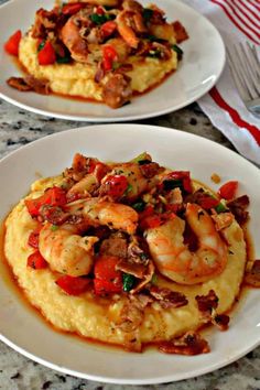 two white plates topped with grits and shrimp