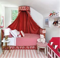 a red canopy bed in a child's bedroom