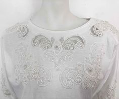 "The Age of Innocence has returned with this white cotton jersey beyond basic tee that is emblazoned with cut out lace floral embroidery x peek a boo see through lace details w/ pearls. Set with shoulder pads. SECTION: WHITE COTTON x COTTAGES MATERIAL: 100% Cotton SIZE: No label- Fits M CONDITION: Excellent Vintage Condition No stains, tears, repairs, rips or holes. ✂ - - - MEASUREMENTS: Inches Chest Width: 22\" Hem Width: 22\" Neck Width: 9\" Sleeve Length: 26\" Length (HPS-high point shoulder Bright Sweater, Fancy Top, The Age Of Innocence, Oversized Sweater Cardigan, Sweet Violets, Fancy Tops, Womens Blouses, Peek A Boo, High Point