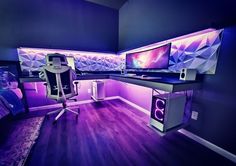 a computer desk with two monitors and speakers on it in a room that has purple lighting