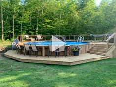 an above ground pool surrounded by wooden decking and patio furniture in the middle of a yard