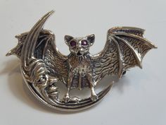 a fine silver bat seated in moon brooch, also has loop to back so can be worn as a pendant. measures 4.5cm wide x 3.2cm high.has a swivel pin clasp to back. BOX FOR DISPLAY ONLY,WILL COME IN GIFT BOX. Browse my shop listings https://www.Etsy.com/uk/shop/Quantiquecollectable Silver Brooch Jewelry For Halloween, Moon Brooch, Fine Silver, Uk Shop, Brooch Pin, Brooches, Cuff Bracelets, Bat, Etsy Accessories