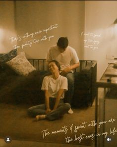 two people sitting on the floor in front of a bed with words written above them