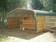 a wooden shed with a metal roof in the woods