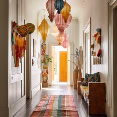 a hallway with colorful lanterns hanging from the ceiling and rugs on the floor in front of it