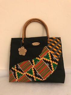 African Kente Handbag/Purse. Elegant and stylish. African Fabric/Multi Colored Bag with bamboo/cane handles.  Handles may vary and subject to availability. Handles may come in bamboo, clear or any other color. Pattern on fabric may also vary  Size is approximately 16.5 (L) x 11 inches (H) X 3.5 (W) Ankara Handbags Kitenge, Traditional Black Rectangular Bag, Traditional Black Rectangular Shoulder Bag, Traditional Black Tote Bag, Traditional Black Tote Shoulder Bag, Traditional Black Handheld Bag, Traditional Black Pouch Bag, Traditional Black Bag For Everyday Use, Traditional Black Shoulder Bag Gift