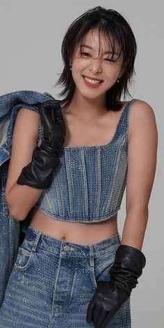 a woman wearing black gloves and a denim top