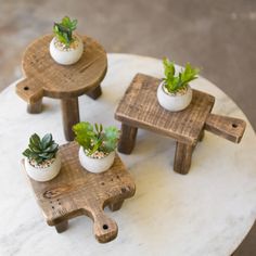 three small wooden stools with plants in them