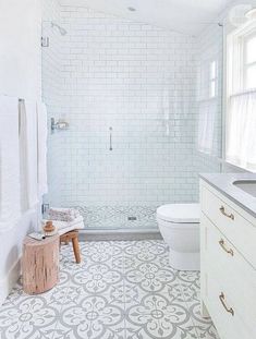 a bathroom with white and gray tiles on the floor