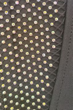 the back of a black jacket with sequins on it's lapel