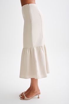 Coastal advetnuresIntroducing the VENEZIA Linen Midi Skirt With Ruffle, a sophisticated and feminine piece for your summer wardrobe. Designed with a mid-rise waist, it offers a flattering silhouette while providing comfort for all-day wear. The mermaid shape accentuates your curves, adding a touch of elegance to your ensemble. With a flared ruffle hem, it creates movement and flair, perfect for adding a playful twist to your look. Featuring a convenient side zipper, it ensures easy wear and a streamlined appearance. Lined for comfort and quality, this skirt is ideal for warm-weather styling. Whether paired with the Venezia Linen One Shoulder Tie Top for a polished look or a casual top for a relaxed vibe, the Venezia Midi Skirt is sure to elevate your outfit with its effortless charm and fe Elegant Relaxed Skirt For Brunch, Elegant Lined Skirt For Brunch, Elegant Ruffled Skirt For Day Out, Beige Tiered Lined Skirt, Fitted Flared Maxi Skirt For Brunch, Elegant Ruffled Maxi Skirt For Day Out, Chic Flared Summer Skirt, Elegant High Waist Maxi Skirt For Brunch, Chic Flared Skirt For Summer