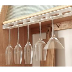 four wine glasses hanging from a wooden rack