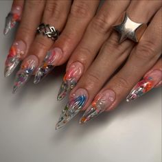 a woman's hands with colorful nails and rings