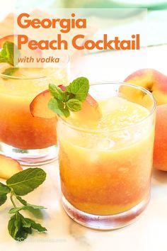 two glasses filled with peach cocktail on top of a table