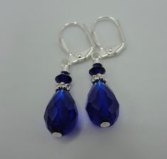 "Beautiful pair of sapphire blue crystal teardrop earrings! Faceted tear drop shaped crystals, sterling silver plated spacers and 4mm Swarovski crystals dangle from the sterling silver plated lever back ear wire. These earrings dangle approximately 7/8\" from the base of the lever back ear wire. Such a beautiful color!" Sapphire Crystal Teardrop Earrings, Blue Crystal Teardrop Dangle Earrings, Blue Crystal Teardrop Earrings For Gifts, Blue Crystal Teardrop Earrings, Sapphire Teardrop Crystal Earrings For Formal Occasions, Sapphire Teardrop Crystal Earrings, Blue Pear-shaped Teardrop Earrings For Anniversary, Blue Pear-shaped Teardrop Earrings, Nickel Free Blue Teardrop Earrings