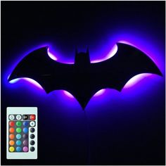 the bat symbol is lit up in purple and blue lights with remote controls on each side