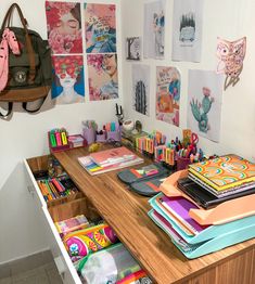 the desk is full of art and craft supplies, including notebooks, pens, pencils and markers