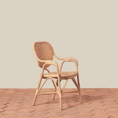 a wicker chair sitting on top of a brick floor