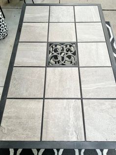 a black and white tile table with an intricate design on the top is shown in this image