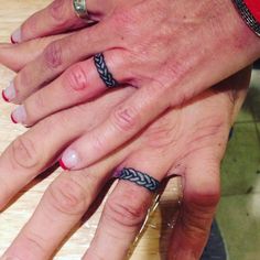 two people's hands with rings on them sitting next to each other at a table