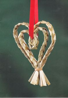 a heart shaped ornament hanging from a red ribbon