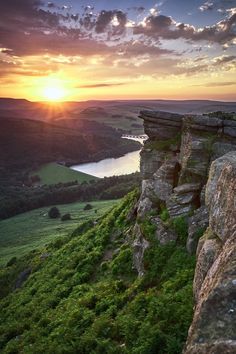 the sun is setting over some rocks and grass