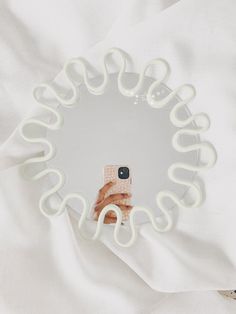 a cell phone sitting on top of a white plate with neon green rings around it