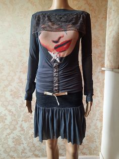 "Vintage punk style dress with a knitted dropped waistband. Grey stretchy fabric with a pink under skirt.  It has a lady's face on the bodice with a brown lace veil. A ruched middle with ornamental hooks and belt and a rara style skirt.  Very 80's.   Has some wear on the belt,  its very stretchy so would easily fit a size up. Bust;  33\" Waist;  30\" Length;  35\" Inside sleeve;   20\" Made by  PATRICIA FORGEAL" Punk Style Dresses For Winter Costume Party, Punk Style Winter Dresses For Costume Party, Fitted Long Sleeve Corset Dress For Halloween, Emo Fitted Long Sleeve Dress, Fitted Long Sleeve Corset Dress With Lace Trim, Vintage Fitted Mini Dress With Lace Patchwork, Fitted Vintage Mini Dress With Lace Patchwork, Punk Fitted Dresses For Fall, Punk Style Fitted Dresses For Fall