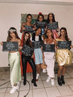 a group of women standing next to each other holding up blackboards with words on them